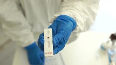 Doktor laboratuvar asistanı koronovirüs covid-19 'un negatif sonucunu belirlemek ve verileri dergiye yazmak için bir test yapıyor. İstatistikler covid-19