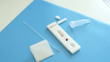 Kullanılmış ekspres test covid-19 kiti yakın çekim. Kan izleriyle test kasedi, negatif sonuç, pipet, korkuluk, reaksiyonlu test tüpü. Sars-Cov-2 Coronovirüs testi
