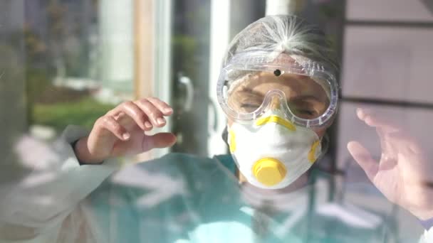 Moe dokter doet haar masker en bril af en leunt met haar hand tegen het glas. Hard werk van artsen tijdens de epidemie van coronavirus covid-19 sars-cov-2 — Stockvideo