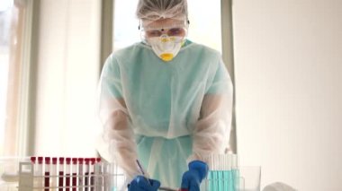 Laboratuvar çalışanı Coronovirus covid-19 sars-cov-2 testlerinin sonuçlarını kaydediyor. Laboratuvar asistanı üzerinde enfekte olmuş Covid-19 kan örneği olan bir test tüpü buldu.