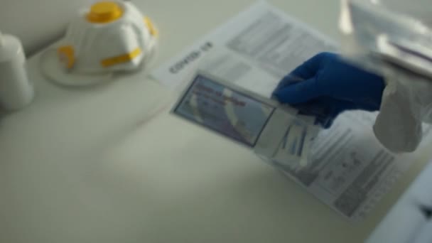 Wroclaw Polen - 23 april 2020. Arts in het bezit van een testkit voor virale ziekte COVID-19 2019-nCoV. Lab kaart kit getest NEGATIVE voor virale nieuwe coronavirus SARS-CoV-2 virus. Sneltest covid 19 — Stockvideo