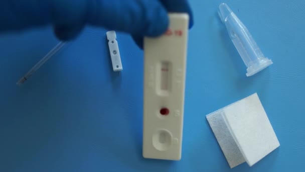 Negatief resultaat van de sneltest van covid-19 op de gebruikte testcassette. Dicht portret van een kit voor de diagnose van coronovirus covid-19 sars-cov-2 door PCR ligt op tafel bij de laboratoriumassistent — Stockvideo