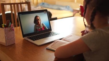 Genç kız ve öğretmeni Skype üzerinden uzaktan iletişim kuruyor. Uzaktan Ders, Karantina Coronovirüs Covid-19