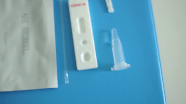 Лабораторный ассистент выкладывает комплект для диагностики короновируса сарс-ков-2 - тестовую кассету, реагенты, скарификатор и дезинфицирующее средство. Испытания кока-колы — стоковое видео