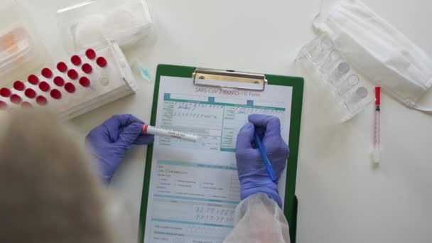 El asistente de laboratorio registra los resultados de un análisis serológico de sangre. Método de PCR para el diagnóstico del coronavirus covid-19 mediante determinación de anticuerpos en plasma sanguíneo — Vídeo de stock