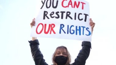 Siyah koruyucu maskeli kız insan hakları ihlalini protesto etti. Karantina süresince Avrupa 'da sosyal protesto ve grevler