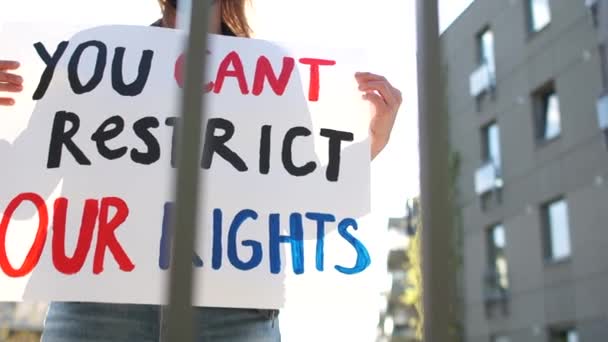 Mujer en una máscara protectora protesta contra la restricción de los derechos civiles cerca del gobierno de la ciudad. Protestas masivas durante la Cuarentena Covid-19. No puedes restringir nuestros derechos. — Vídeo de stock