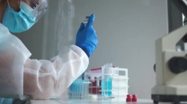 Araştırmacı, Covid-19 Coronavirus enfeksiyonunun kan örneklerini inceliyor. Laboratuvar asistanı, koronavirüs teşhisi için laboratuvar testleri için pipet dağıtıcısı kullanır.