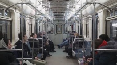 Moskova - Ocak 2017: Moskova metrosundaki metro, modern Rus metrosu bir istasyondan diğerine hareket ediyor, pencerelerden ışıklar akıyor. İnsanlar oturup bekliyor..