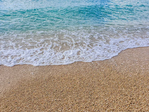 Praia de seixos e espuma de onda — Fotografia de Stock