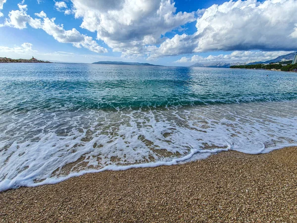 Spiaggia di ghiaia e schiuma ondulata — Foto Stock