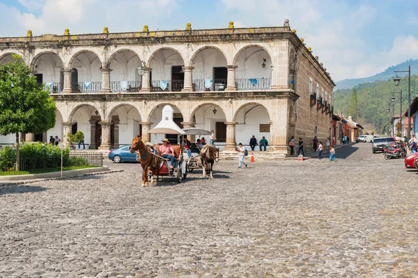 Huizen en verkeer door belangrijkste plaza in Antigua, Guatemala. — Stockfoto