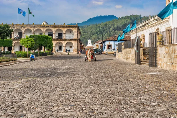 Családi házak és a forgalom fő plaza itt: Antigua, Guatemala. — Stock Fotó