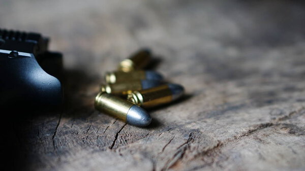 Bullets and gun on the wood