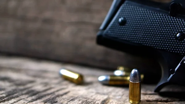 Balas y pistola en la madera — Foto de Stock
