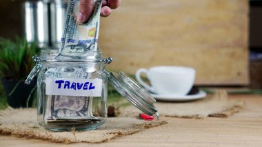 Money savings for travel on the wood desk and nature background