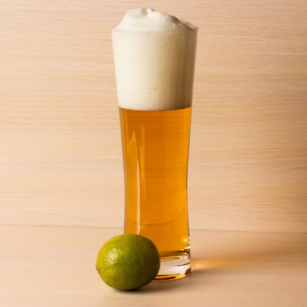 Botella fría de cerveza con lima sobre fondo blanco —  Fotos de Stock