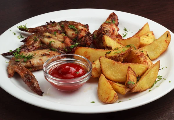 tavuk kanadı bir tabak patates Fransız ve baharatlı sos ile