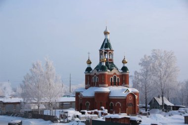 Kışın kar kaplı ağaçlar ve kilise