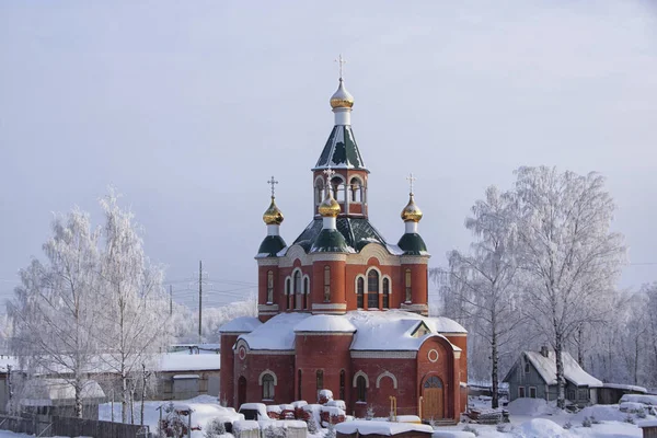 Igreja e neve branca árvores cobertas em um dia de inverno Imagem De Stock