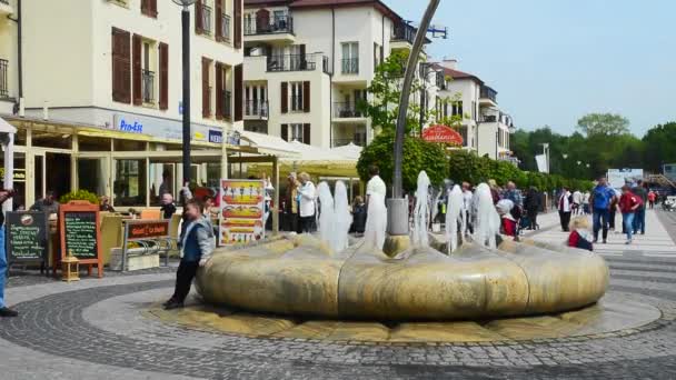 People walk about a fountain in Swinoujscie, Poland — Stock Video