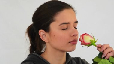 Genç kadın bir çiçek kokuyor