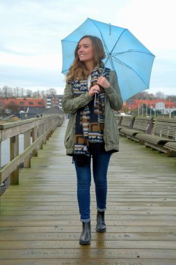 Genç kadın bir ayak iskelede Sonbahar zaman içinde yürür.