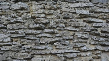 Duvardaki gri taşlar çimentoyla güçlendirilmiş.
