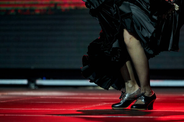 Woman legs dance flamenco black skirt and shoes in a concert