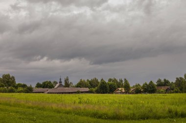 Rüzgarlı gün yazdırma üzerinde tipik bir Köyü üzerinden ağır bulutlar