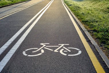 Beyaz ve sarı şerit işareti ve bir bisiklet güneş ışınları ile görüntüsünü yolda Bisiklet