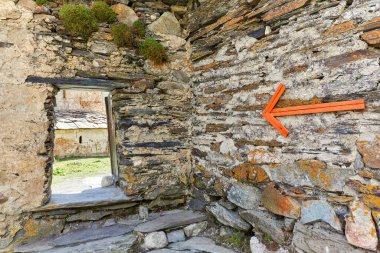 the pointer on the stone wall in on right