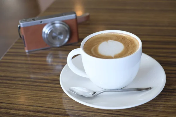 Cafe latte i aparat cyfrowy na tabeli — Zdjęcie stockowe