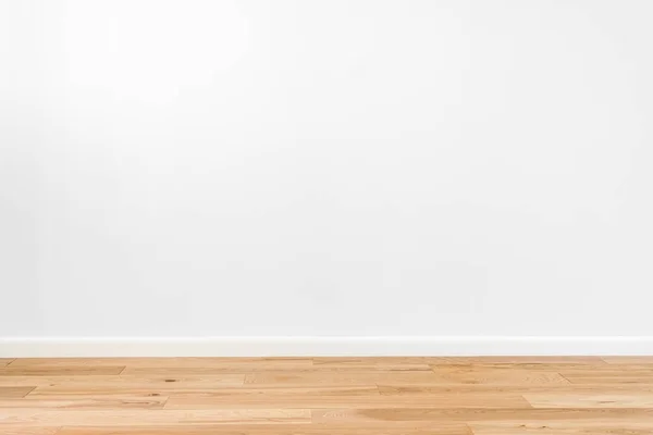 Pared de estuco pintada de blanco y suelo de madera de fresno de madera natural de parquet de 3 bandas. Suelos en estilo escandinavo de interior vacío con amplios zócalos blancos. Marrón claro, color galleta — Foto de Stock