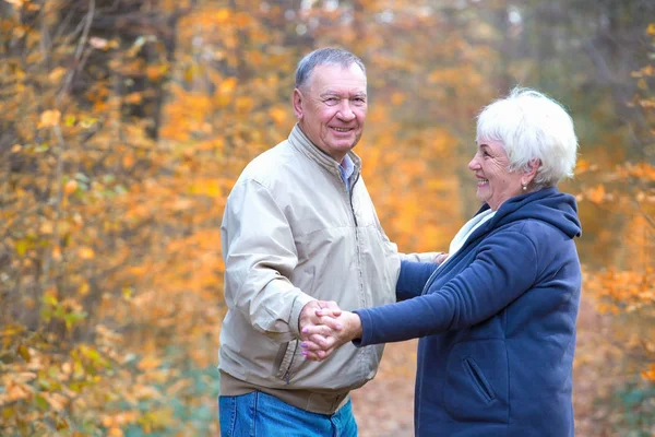 Feliz casal de idosos dançando em uma caminhada de outono — Fotografia de Stock
