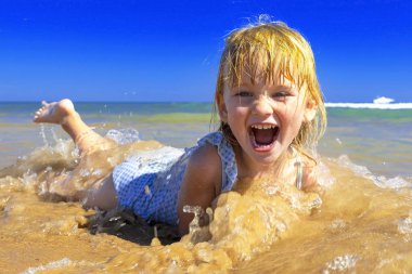 Denizde oynayan mutlu çocuk.