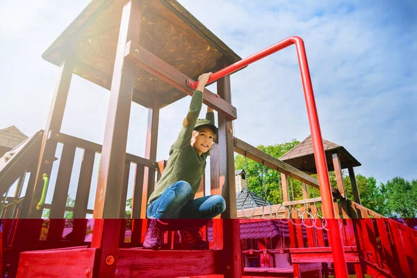 Nyfiken orädd liten flicka klättring på lekplatsen ensamma i soligt väder — Stockfoto