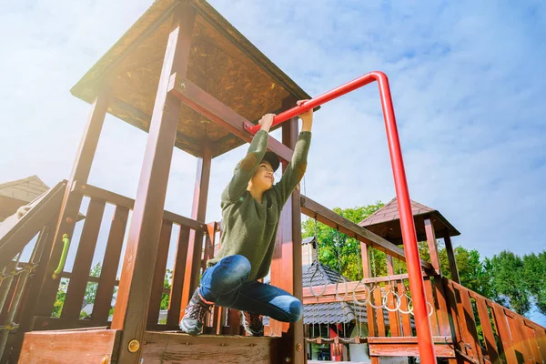 Nyfiken orädd liten flicka klättring på lekplatsen ensamma i soligt väder — Stockfoto
