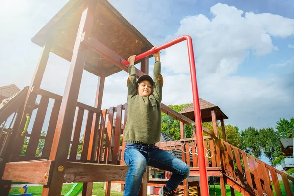 Curiosa niña intrépida escalando en el patio de recreo sola en tiempo soleado —  Fotos de Stock