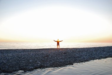 Adam kollarını batan güneşin karşı yaymak