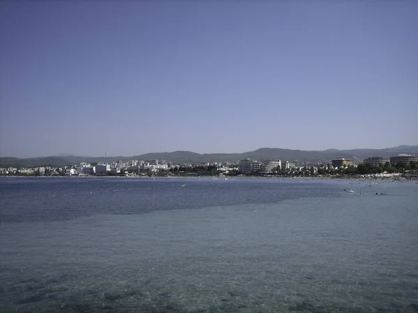 Côte Une Mer Calme Avec Des Bâtiments Verdure Par Une — Photo