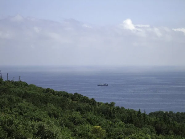 Sea view from the coastal mountains. The coastal hills are surrounded by dense vegetation.
