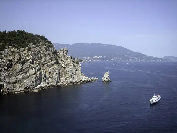 高高的岩石群山耸立在风景如画的海湾蓝色的水面之上 游船在那里航行 — 图库照片