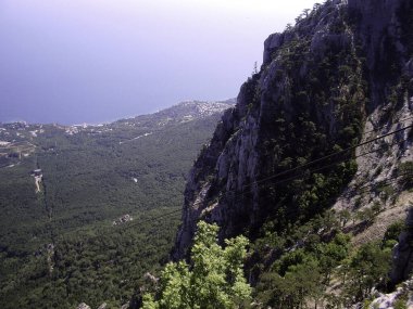 Yüksek dağdan denize ve dağın eteğindeki yoğun yeşil ormana bakın..