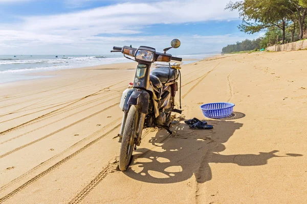 De motorfiets staat op het strand. Stockfoto