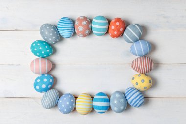 Elipsin alanı olan beyaz ahşap arka plan üzerinde renkli Paskalya yumurta. Düz yatıyordu stili