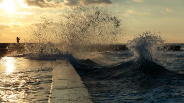 Bir adam bir deniz fırtına fotoğrafını. Gün batımı arka plan üzerinde deniz manzarası