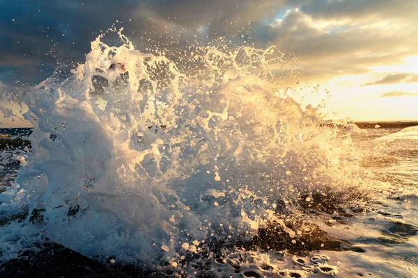 夕日の背景に古い防波堤クローズ アップに海の波のクラッシュします。 — ストック写真