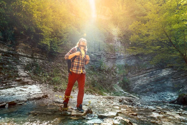 Homem viajante atravessar o rio da montanha para um wade — Fotografia de Stock