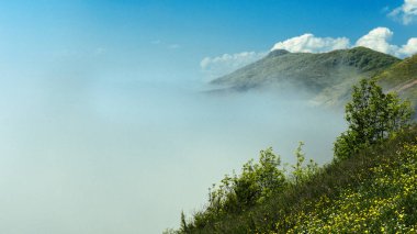 Sabah güzel manzara doğada en yüksek dağ güneş ışığı bulut sis ve parlak mavi gökyüzü ile